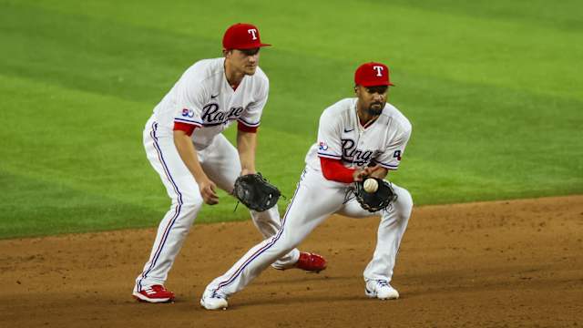 Apr 12, 2022; Arlington, Texas, USA; Texas Rangers second baseman Marcus Semien (2) fields a ground ball in front of Texas Rangers shortstop Corey Seager (5) during the fifth inning against the Colorado Rockies at Globe Life Field. Mandatory Credit: Kevin Jairaj-USA TODAY Sports